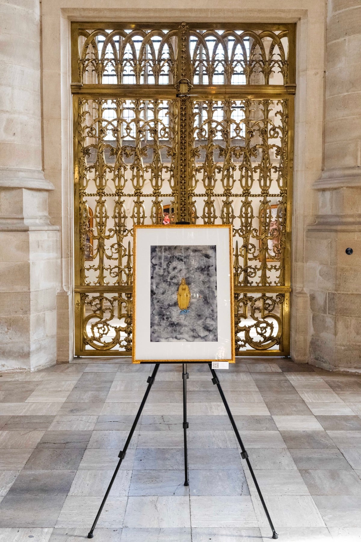 Framed miniature artwork in front of an ornate screen at the Laurenskerk